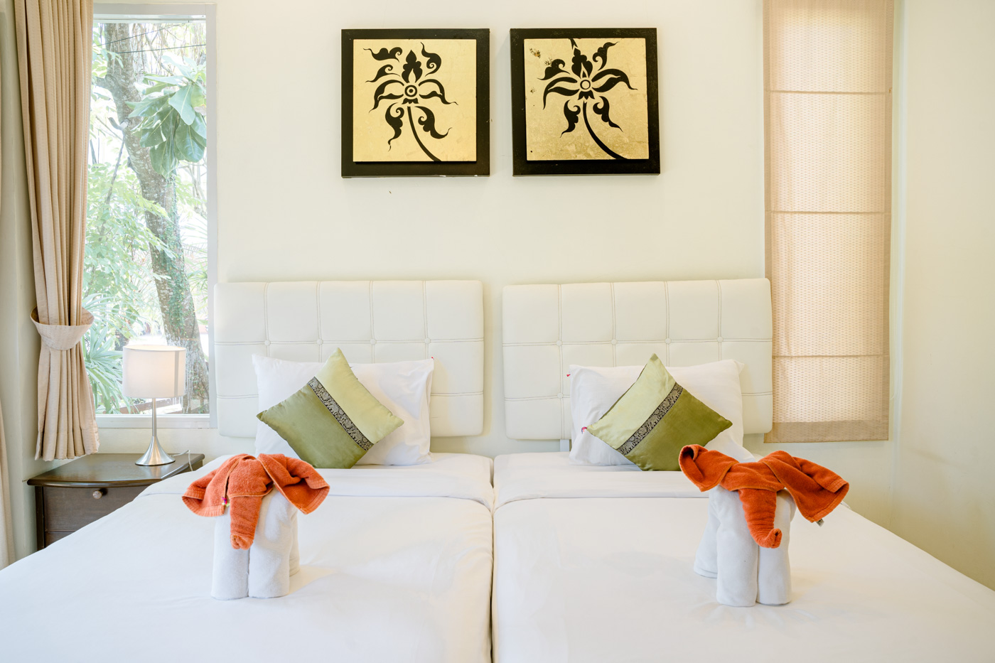 Camera da letto privata in villa con due letti singoli, cuscini decorativi e luci soffuse